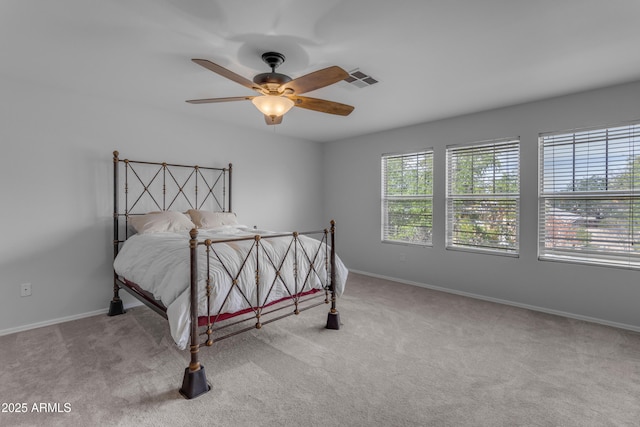 carpeted bedroom with visible vents, ceiling fan, and baseboards