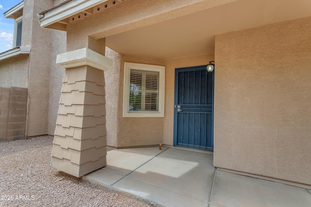 entrance to property with a patio area and stucco siding