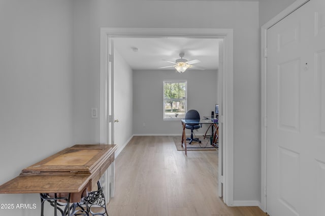 hall featuring light wood-style floors and baseboards