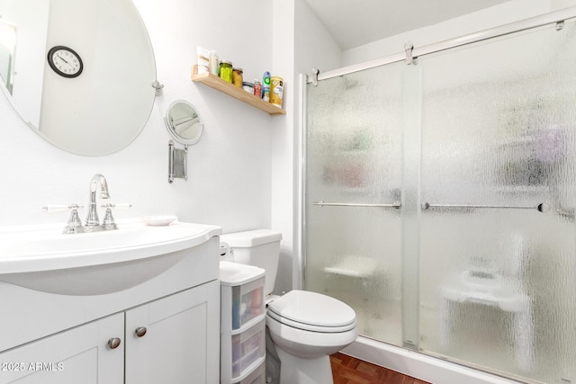 bathroom featuring parquet flooring, vanity, toilet, and a shower with door