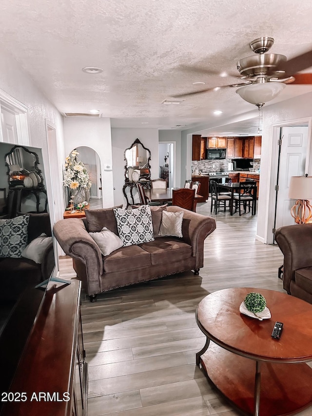 914 E 16th St, Douglas, AZ 85607 - living area with arched walkways, light wood-type flooring, recessed lighting, ceiling fan, and a textured ceiling