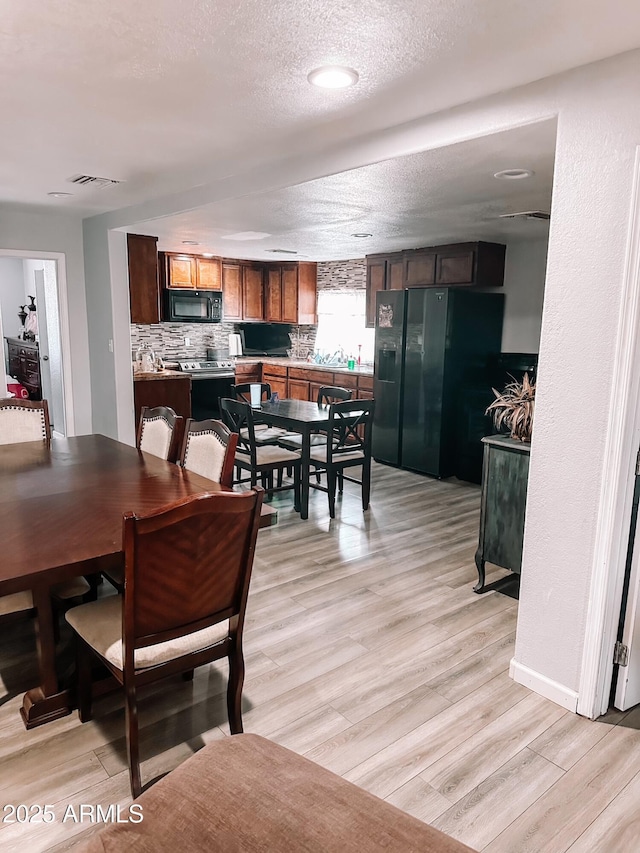 914 E 16th St, Douglas, AZ 85607 - dining space with light wood-style floors and a textured ceiling