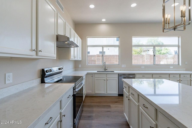 kitchen featuring white cabinetry, sink, a notable chandelier, decorative light fixtures, and appliances with stainless steel finishes