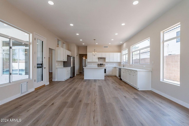 kitchen featuring a kitchen island, white cabinets, pendant lighting, and appliances with stainless steel finishes