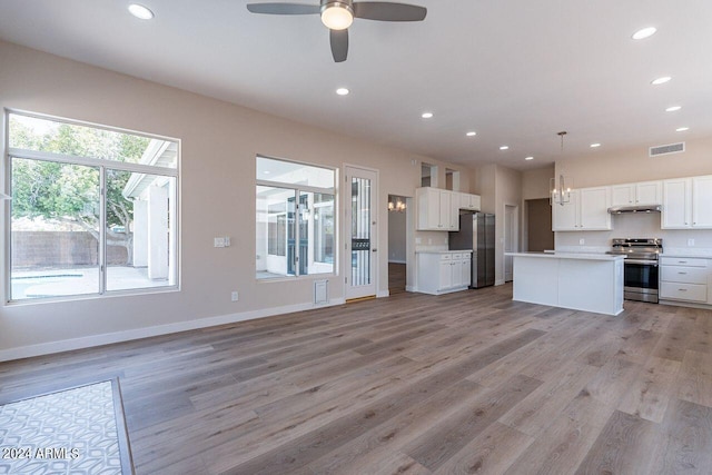 kitchen featuring stainless steel appliances, white cabinets, a center island, light hardwood / wood-style floors, and hanging light fixtures