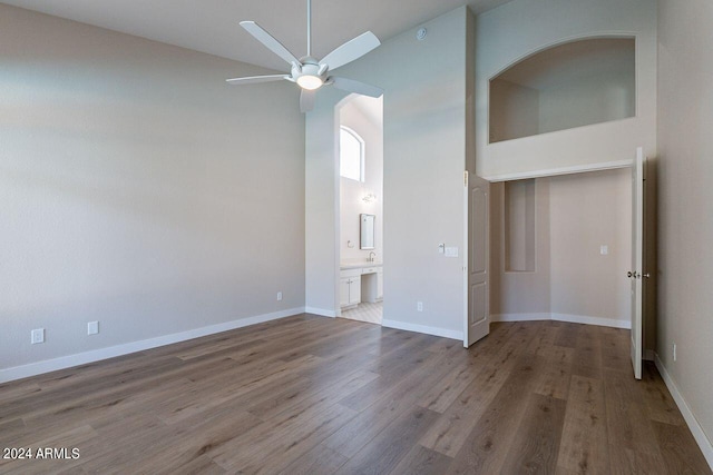 unfurnished living room with wood-type flooring, high vaulted ceiling, and ceiling fan