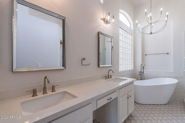 bathroom featuring vanity, a washtub, tile patterned flooring, and an inviting chandelier