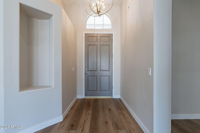 entryway with hardwood / wood-style floors and an inviting chandelier