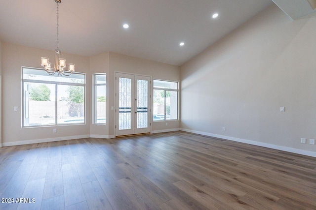 unfurnished room featuring a chandelier, french doors, dark hardwood / wood-style flooring, and lofted ceiling