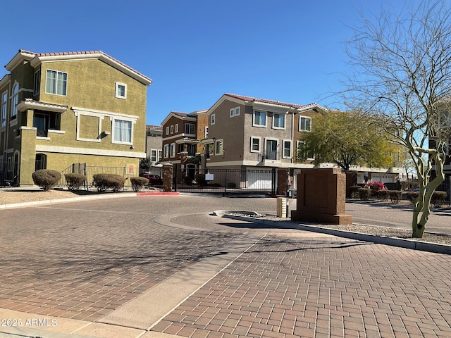 view of road featuring curbs, a gated entry, a gate, and a residential view