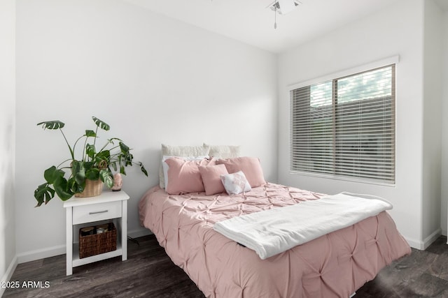 bedroom with baseboards and dark wood-type flooring