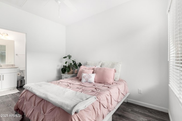 bedroom featuring baseboards, dark wood finished floors, and connected bathroom