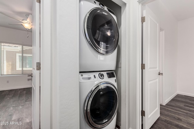 washroom featuring laundry area, baseboards, a ceiling fan, stacked washer and clothes dryer, and dark wood-style flooring