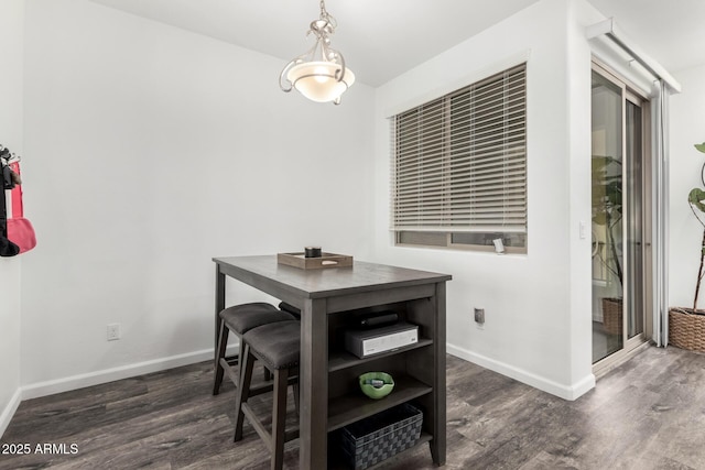 dining space with dark wood finished floors and baseboards