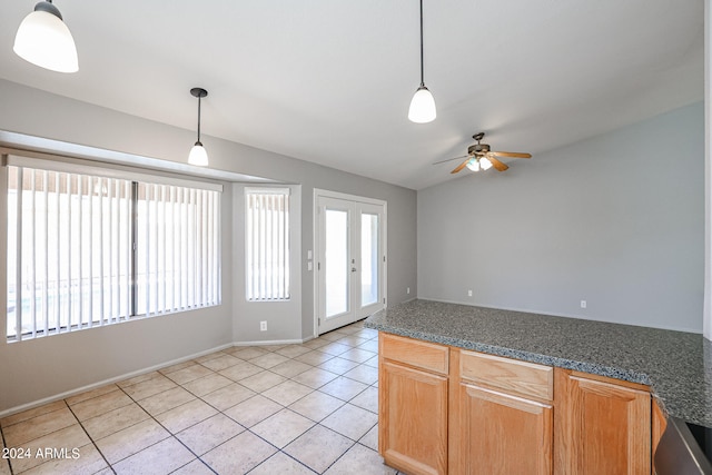 spare room featuring light tile floors, lofted ceiling, and ceiling fan