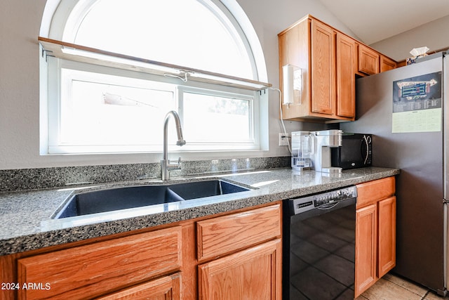 kitchen featuring lofted ceiling, sink, light tile floors, dark stone countertops, and dishwasher