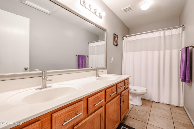 bathroom featuring toilet, tile floors, dual sinks, and large vanity