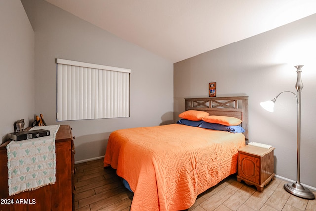 bedroom featuring light wood-type flooring and lofted ceiling