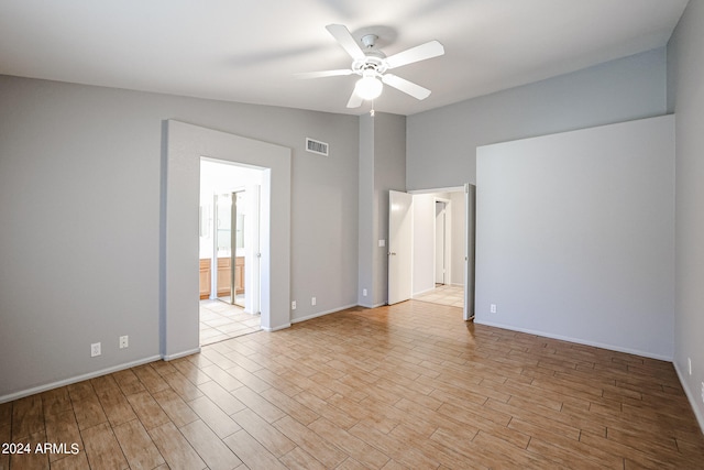 unfurnished room featuring ceiling fan, vaulted ceiling, and light hardwood / wood-style flooring