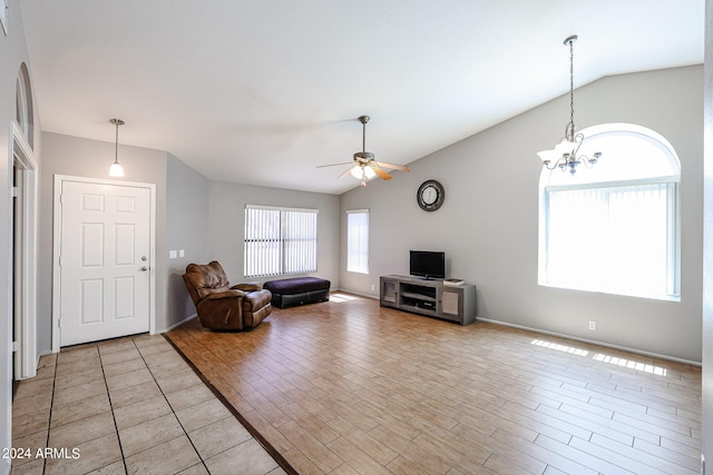 unfurnished living room featuring light tile floors, lofted ceiling, and ceiling fan with notable chandelier