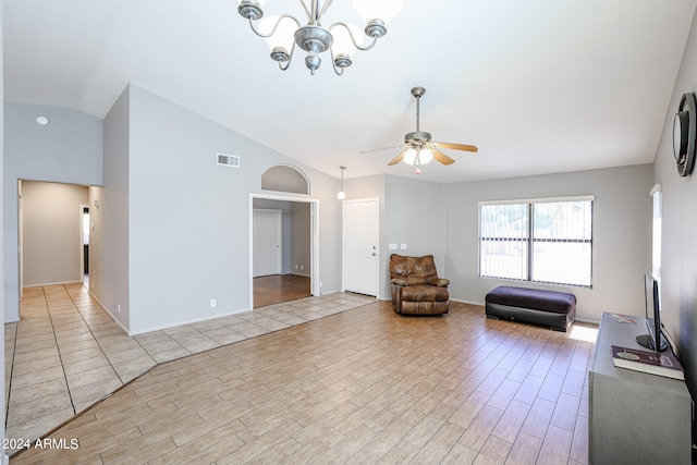 unfurnished room with lofted ceiling, ceiling fan with notable chandelier, and light tile flooring