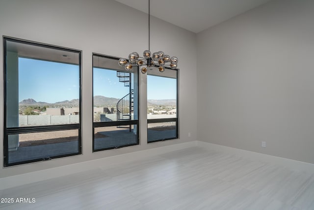 spare room with a mountain view and a notable chandelier