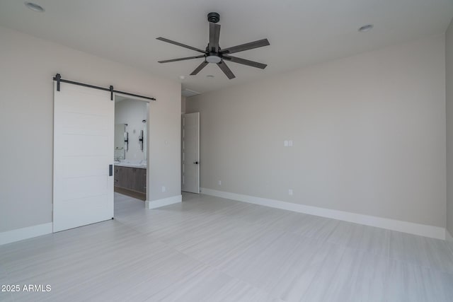 empty room with ceiling fan and a barn door