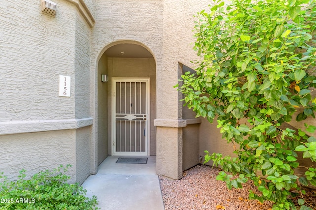 view of exterior entry with stucco siding