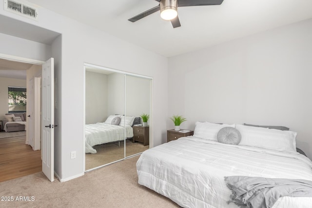 bedroom featuring visible vents, baseboards, a closet, carpet, and a ceiling fan
