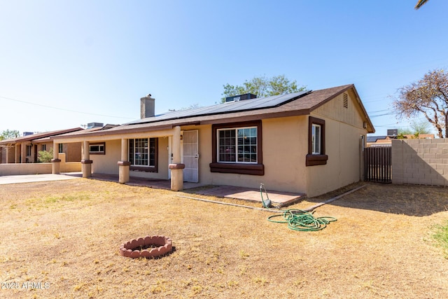 2064 W 2nd St, Mesa, AZ 85201 - rear view of property with a chimney, roof mounted solar panels, a patio area, and stucco siding