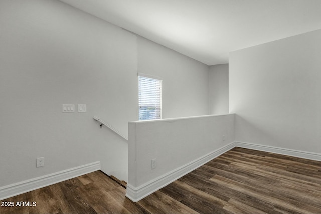 empty room with dark wood finished floors and baseboards