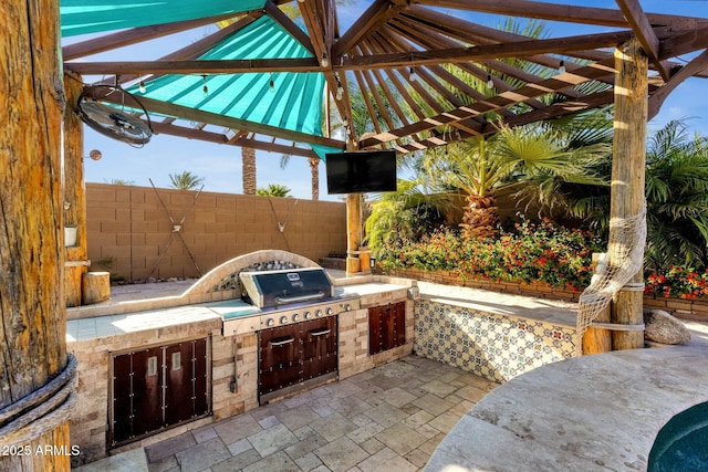 view of patio / terrace with a pergola, an outdoor kitchen, and fence