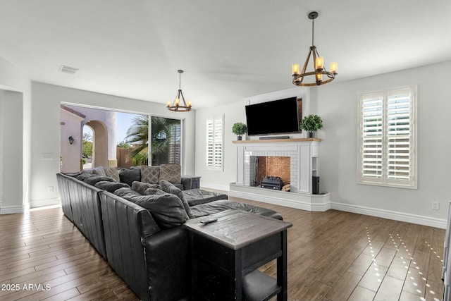 living room featuring visible vents, an inviting chandelier, and a healthy amount of sunlight