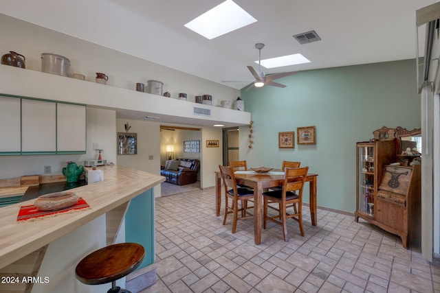 dining room featuring ceiling fan and lofted ceiling with skylight