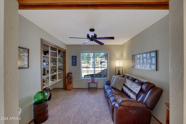 living room featuring ceiling fan, carpet, and a textured ceiling