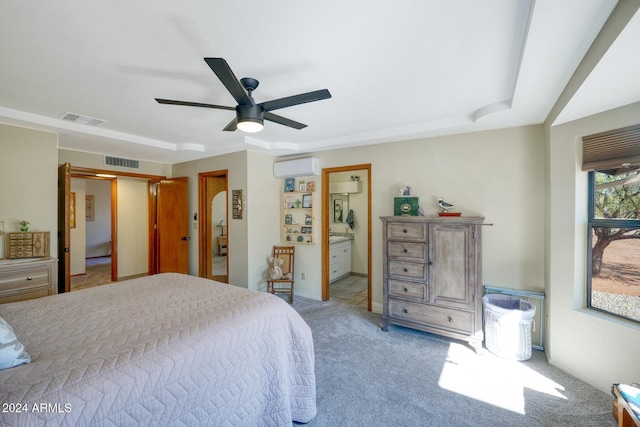 carpeted bedroom featuring ensuite bathroom, ceiling fan, and a wall unit AC