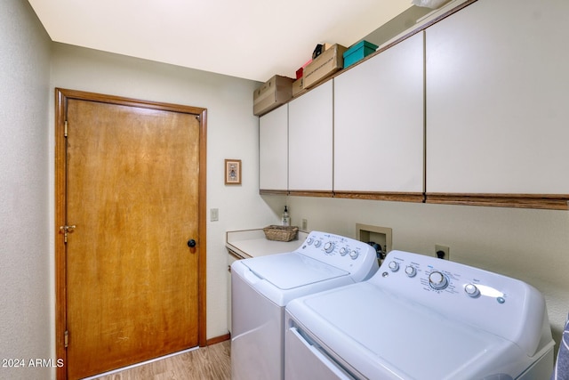 laundry room with cabinets, separate washer and dryer, and light hardwood / wood-style flooring