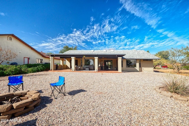 rear view of house with a patio area and an outdoor fire pit