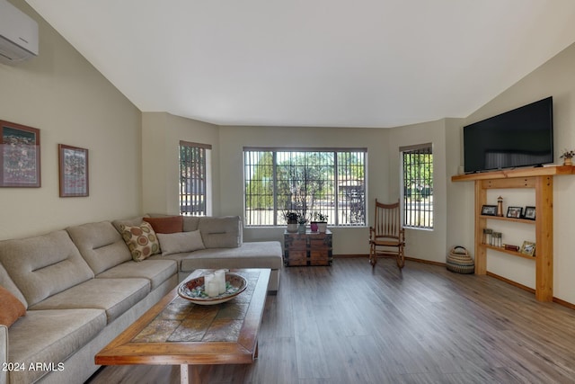 living room with hardwood / wood-style floors, lofted ceiling, and a wall unit AC