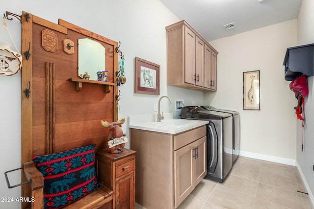 laundry area featuring cabinets, light tile patterned flooring, sink, and washing machine and dryer