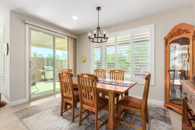 tiled dining room with a chandelier