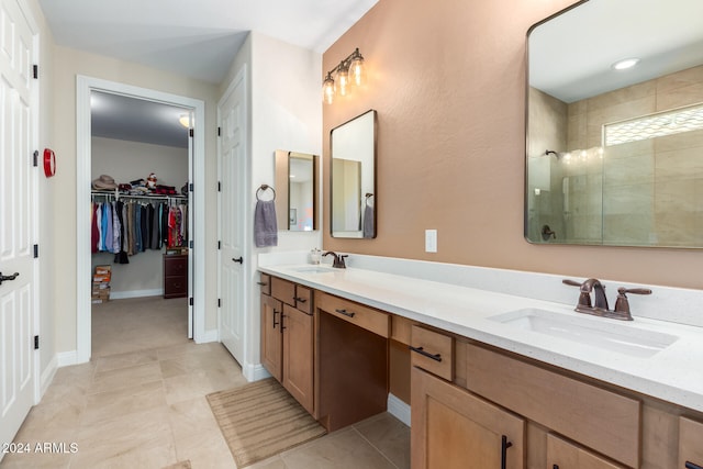 bathroom with vanity, a tile shower, and tile patterned floors