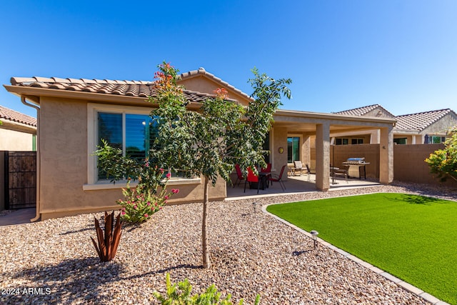 rear view of property with a patio and a lawn