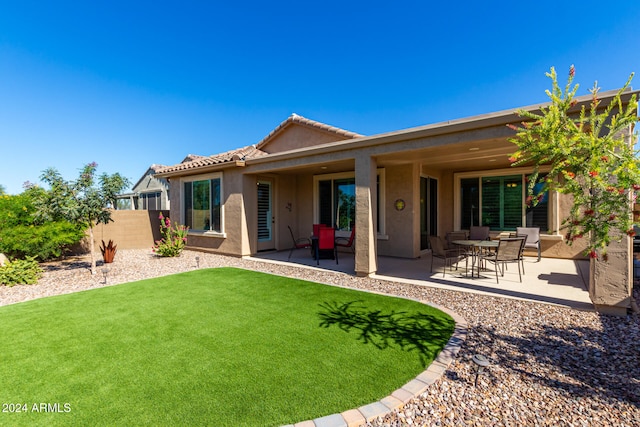 rear view of property featuring a yard and a patio