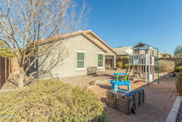 rear view of property with a playground