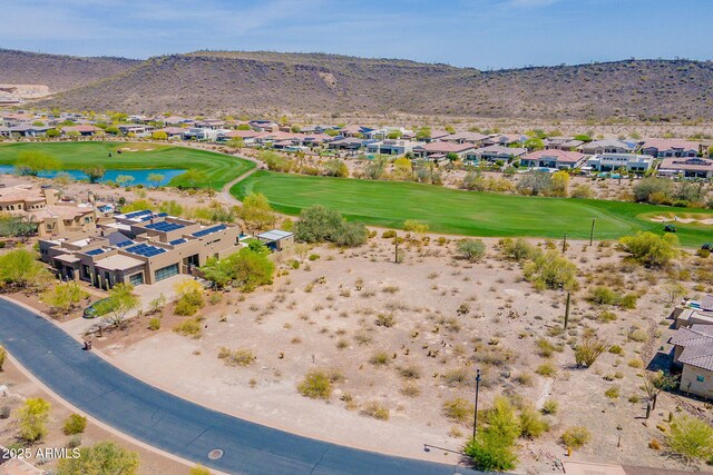 drone / aerial view featuring a residential view, golf course view, and a water and mountain view