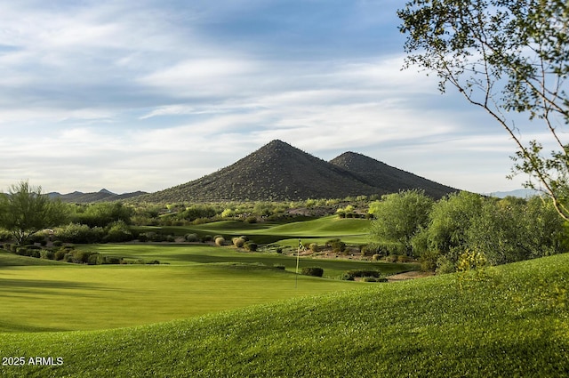 view of community with a yard, golf course view, and a mountain view