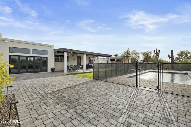 view of patio / terrace featuring ceiling fan and a fenced in pool