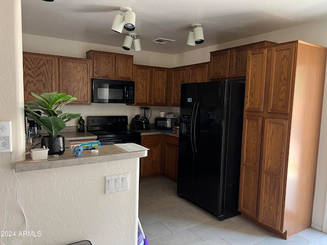 kitchen with light tile patterned flooring and black appliances