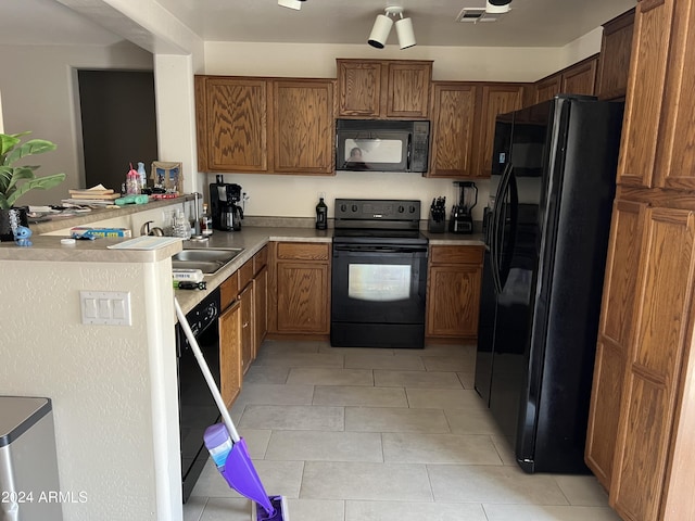 kitchen featuring light tile patterned flooring, kitchen peninsula, and black appliances